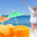 woman enjoying the view of the ocean with umbrella cocktail drinks because she hired a property management company