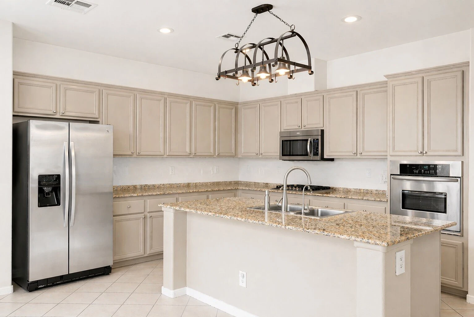 Green Valley Ranch kitchen with large island, stainless steel appliances, neutral cabinets and tile flooring